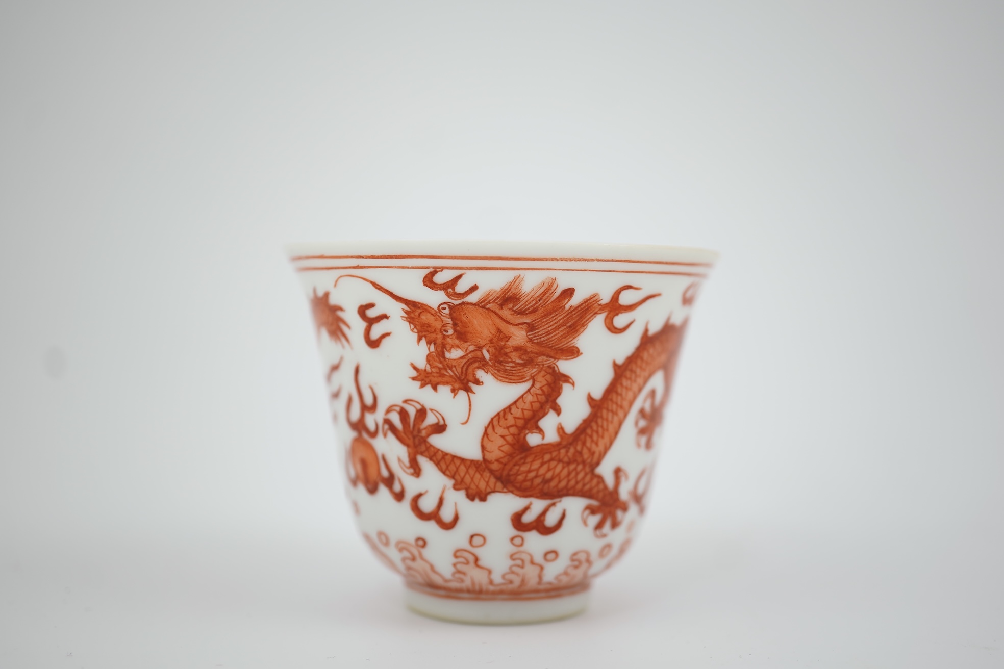 A pair of Chinese iron red ‘dragon’ cups, Guangxu six character mark and probably of the period (1875-1908)